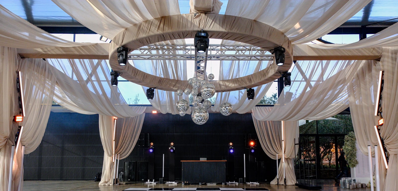 A reception set by Xtreme Events: a draped canopy ring with moving heads, mirror balls, the DJ booth and a black-and-white dancefloor